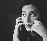 Black and white photo of upset woman talking on a cell phone
