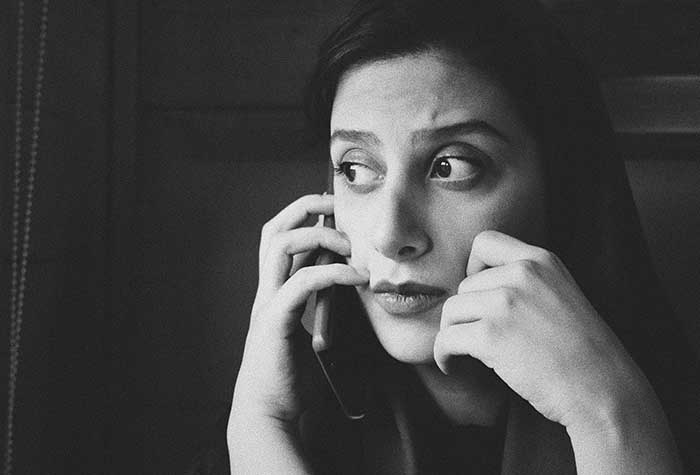 Black and white photo of upset woman talking on a cell phone